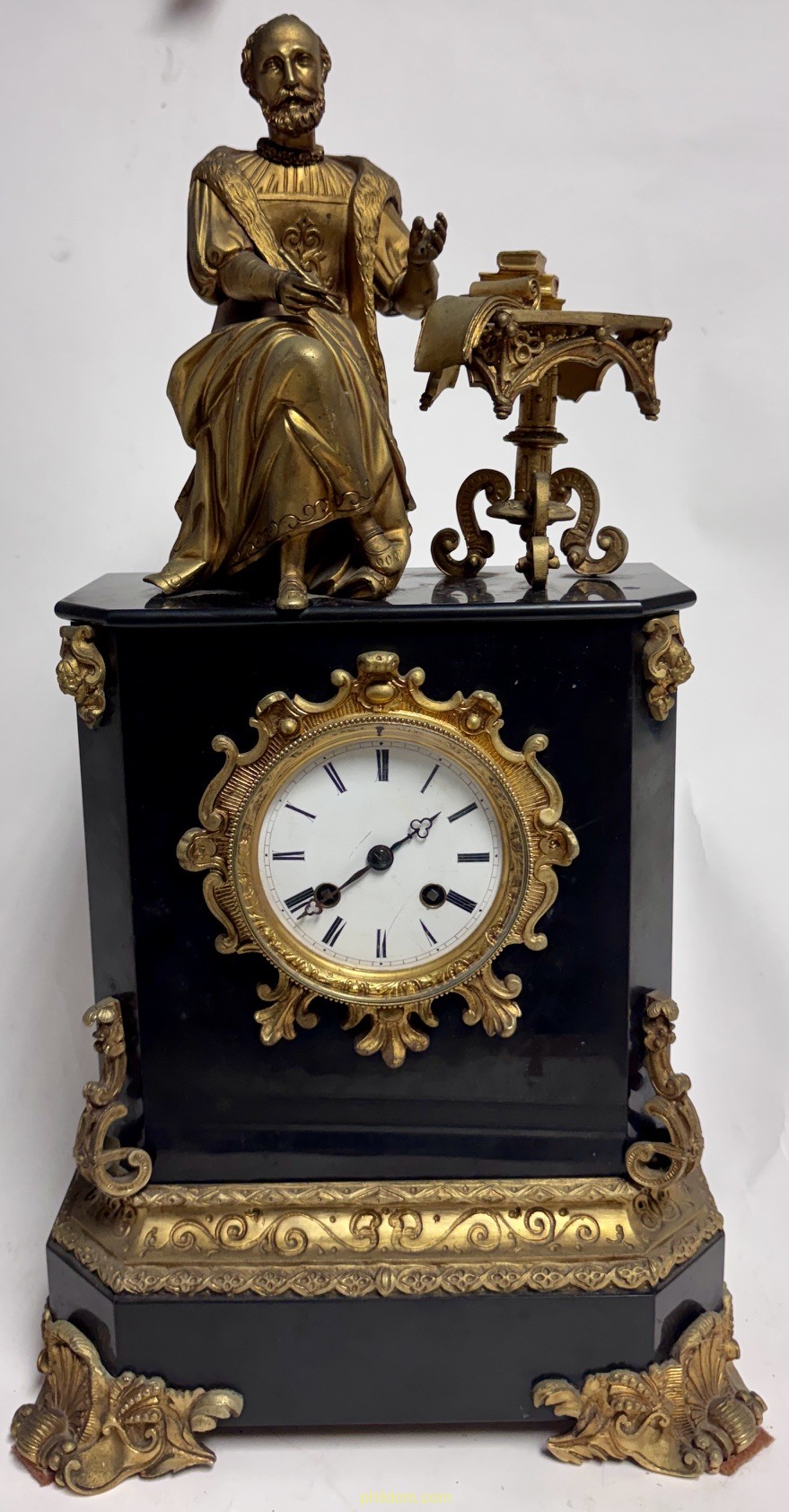 RELOJ SOBREMESA EN MARMOL NEGRO Y BRONCE DORADO CORONADO POR FIGURA DE ESCRITOR BARROCO. Flees. s.XIX